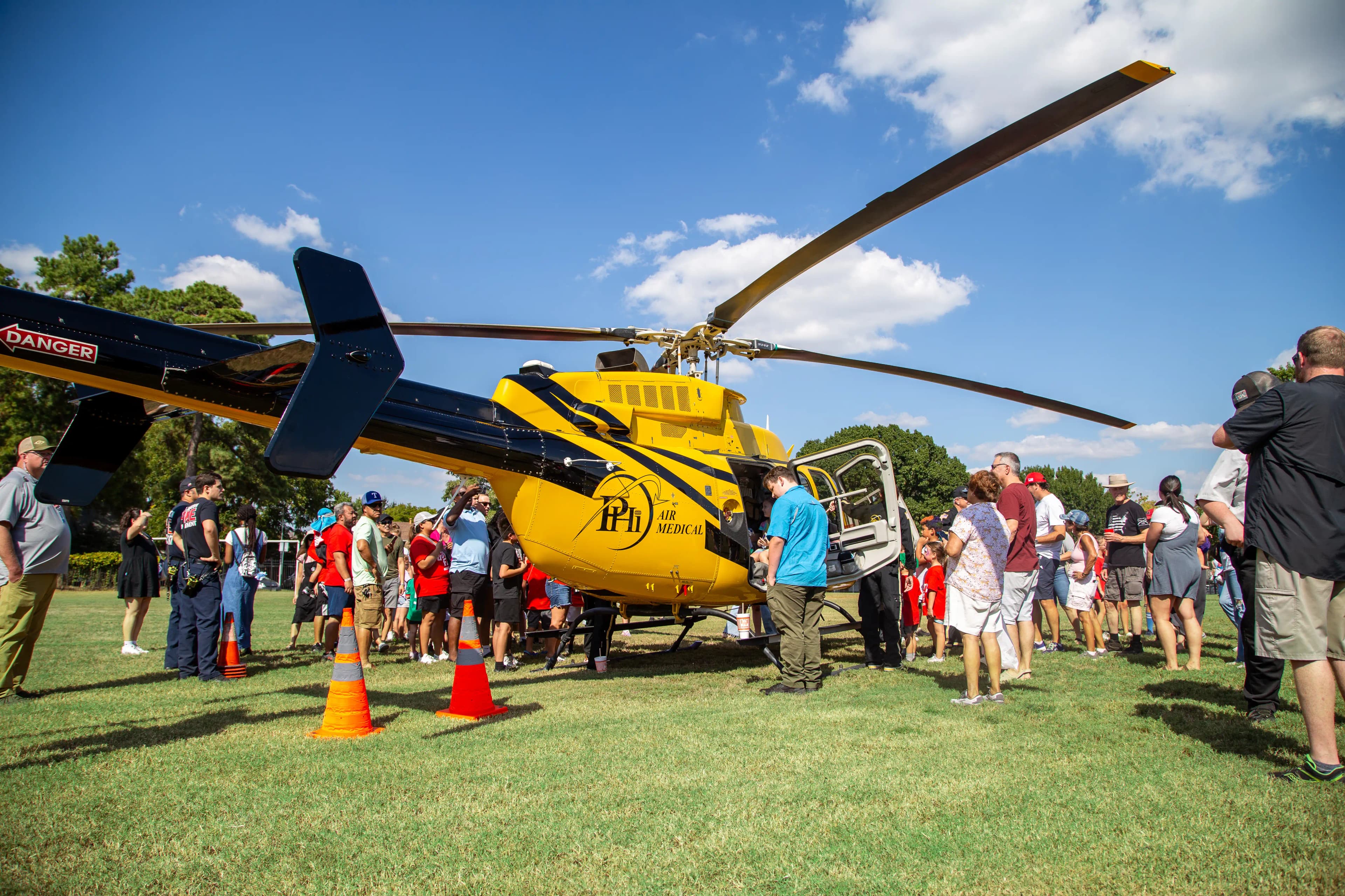 A medical helicopter on the field at GorettiFest with guests and families gathering around to look